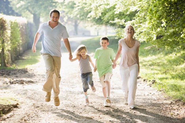 Family running outdoors holding hands and smiling Kako poboljšati cirkulaciju