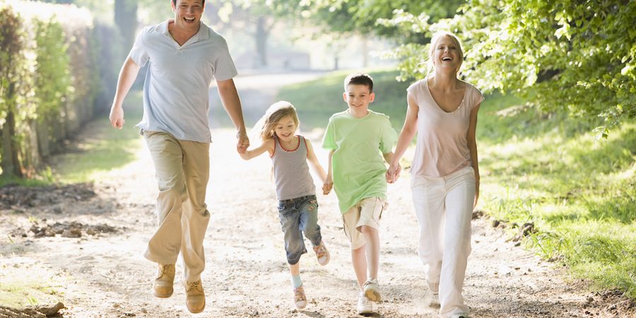 Family running outdoors holding hands and smiling Kako poboljšati cirkulaciju